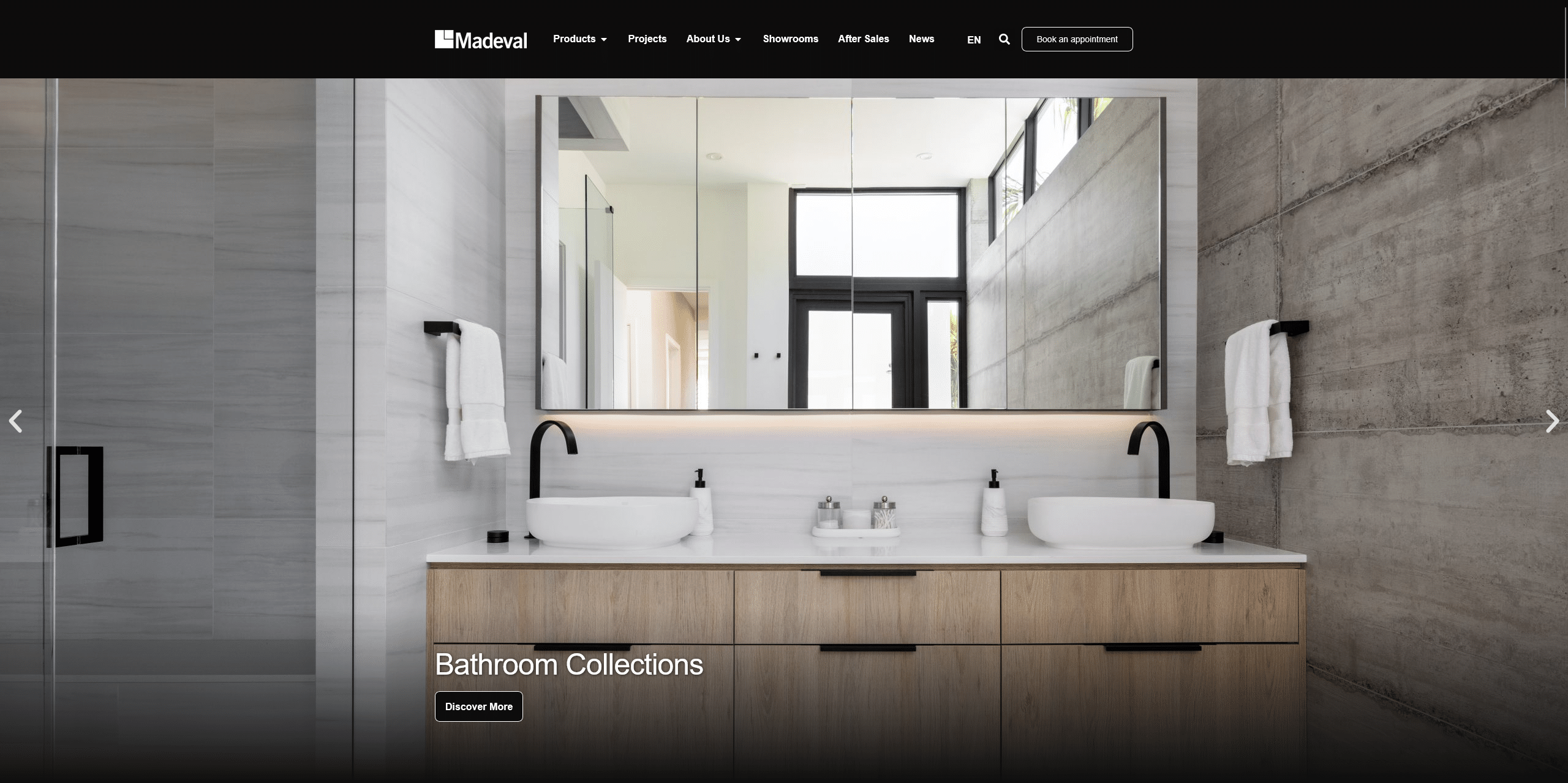 Modern bathroom with double sinks, wood cabinetry, and large mirrors.